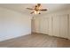 This bedroom features a ceiling fan, light wood floors, and ample closet space at 4622 E Flower Ave, Mesa, AZ 85206