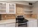 Kitchen detail with mosaic backsplash, stone countertops, and modern stainless steel oven at 4622 E Flower Ave, Mesa, AZ 85206