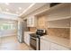 Charming kitchen featuring stainless steel appliances, white cabinets, and a mosaic backsplash at 4622 E Flower Ave, Mesa, AZ 85206
