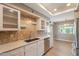 Bright kitchen featuring stainless steel appliances, stone countertops, and eye-catching backsplash at 4622 E Flower Ave, Mesa, AZ 85206