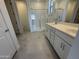 Bright bathroom with double sink vanity, sleek cabinetry, glass enclosed shower, and tile flooring at 20542 N 226Th Ln, Surprise, AZ 85387