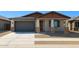 Charming single-story home with stone accents, a gray garage door, and a well-manicured front yard at 20542 N 226Th Ln, Surprise, AZ 85387
