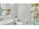 Elegant bathroom with a white sink, toilet, and a decorative shelving unit at 4276 E Meadowview Dr, Gilbert, AZ 85298