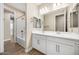 Bathroom with a double sink vanity, framed mirrors and a shower-tub combo at 20254 W Roma Ave, Litchfield Park, AZ 85340