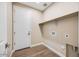 Laundry room with tile flooring, storage shelf and utility hookups at 20254 W Roma Ave, Litchfield Park, AZ 85340