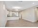 Open-concept living room and kitchen featuring wood-look tile floors and neutral paint at 20254 W Roma Ave, Litchfield Park, AZ 85340