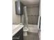 Well lit bathroom with gray wall tile, toilet, tub, and vanity at 2142 E Donner Dr, Tempe, AZ 85282