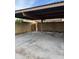 View of a covered carport with a concrete floor and block walls, providing sheltered parking at 2142 E Donner Dr, Tempe, AZ 85282