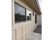 Tan home exterior showing large windows with neutral trim, and rock landscaping adjacent to a concrete walkway at 2142 E Donner Dr, Tempe, AZ 85282