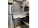 Modern kitchen features stainless steel appliances, gray cabinets, and white quartz counters with sleek backsplash at 2142 E Donner Dr, Tempe, AZ 85282