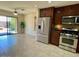 Well-lit kitchen features stainless steel appliances and backyard access through sliding glass door at 1245 N Compton Cir, Mesa, AZ 85207