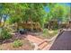 Spacious backyard has multiple seating areas and lush landscaping that offer a peaceful retreat under the trees at 35202 N 30Th Dr, Phoenix, AZ 85086
