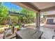 Inviting covered patio includes a seating area, fire pit, and pergola extending into a well-maintained backyard at 35202 N 30Th Dr, Phoenix, AZ 85086