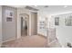 Bright hallway with carpet, featuring an arched doorway and decorative wall art creating a warm and inviting space at 35202 N 30Th Dr, Phoenix, AZ 85086