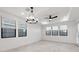 Spacious bedroom featuring a modern chandelier, ceiling fan, and large windows for ample natural light at 4430 N 203Rd Dr, Buckeye, AZ 85396