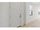 Welcoming entryway with a solid white door, light tile floors, and a glimpse of natural light from a window at 4430 N 203Rd Dr, Buckeye, AZ 85396