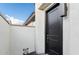Home's private entryway, featuring a modern, black door set against a bright, neutral exterior wall at 4430 N 203Rd Dr, Buckeye, AZ 85396