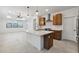 Modern kitchen with stainless steel appliances, a large island with a sink and cabinets, and stylish pendant lighting at 4430 N 203Rd Dr, Buckeye, AZ 85396