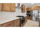 Contemporary kitchen features stainless steel appliances, wood cabinets, and white subway tile backsplash at 4430 N 203Rd Dr, Buckeye, AZ 85396