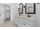 Bright bathroom features a double sink vanity with framed mirrors and a separate walk in closet at 16625 N Lunar St, Maricopa, AZ 85138