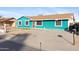 View of the teal home, showcasing the driveway and simple desert landscaping at 323 N 69Th Ave, Phoenix, AZ 85043