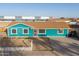 Charming single-story home with vibrant blue paint, a brown roof and a well maintained front yard at 323 N 69Th Ave, Phoenix, AZ 85043