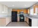 Well-lit kitchen with stainless steel microwave, updated counters and tile floors at 323 N 69Th Ave, Phoenix, AZ 85043