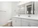 A bright bathroom with a double vanity, white cabinets, and a large mirror at 5335 W Manzanita Dr, Glendale, AZ 85302