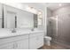 Elegant bathroom featuring a double vanity, large mirror, and a glass-enclosed shower with tiled walls at 5335 W Manzanita Dr, Glendale, AZ 85302