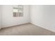 A bright, carpeted bedroom with neutral paint, trim, and a window at 5335 W Manzanita Dr, Glendale, AZ 85302