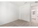 A carpeted bedroom with a closet and a bathroom door, neutral paint, and carpet at 5335 W Manzanita Dr, Glendale, AZ 85302