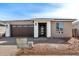 Charming single-story home featuring a stone facade, modern garage door, and well-maintained landscaping at 5335 W Manzanita Dr, Glendale, AZ 85302