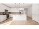 Bright kitchen boasts white cabinetry, stainless steel appliances, and a large center island with pendant lighting at 5335 W Manzanita Dr, Glendale, AZ 85302
