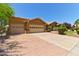 Inviting single-story home with a two-car garage, brick driveway, and desert landscaping at 8894 E Sheena Dr, Scottsdale, AZ 85260