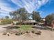 Charming single-story home featuring a metal roof, mature trees and desert landscaping at 26415 S Recker Rd, Queen Creek, AZ 85142