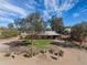 Charming single-story home featuring a metal roof, mature trees and desert landscaping at 26415 S Recker Rd, Queen Creek, AZ 85142