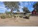 Exterior view of a ranch style home featuring mature landscaping and a gated perimeter fence at 26415 S Recker Rd, Queen Creek, AZ 85142