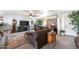 Spacious living room with a large window, a stone wall, and a brown sectional sofa at 26415 S Recker Rd, Queen Creek, AZ 85142