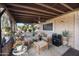 Cozy covered patio featuring comfortable seating, ceiling fan, and brick accent wall at 26415 S Recker Rd, Queen Creek, AZ 85142