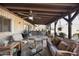 Cozy covered patio featuring comfortable seating, ceiling fan, and brick accent wall at 26415 S Recker Rd, Queen Creek, AZ 85142