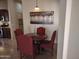 Cozy dining area featuring a round wood table, four red upholstered chairs, and stylish overhead lighting at 6202 E Mckellips Rd # 65, Mesa, AZ 85215