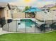 Inviting backyard oasis featuring a sparkling pool, patio, and safety fence at 15402 W Old Oak Ln, Surprise, AZ 85379
