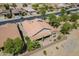 This aerial view shows a tile roof and covered back patio in a desert landscape, perfect for enjoying the outdoors at 34 N Agua Fria Ln, Casa Grande, AZ 85194