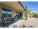 Covered back patio with outdoor dining set. Backyard has desert landscaping and low maintenance at 34 N Agua Fria Ln, Casa Grande, AZ 85194