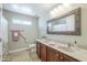 Neutral bathroom with double sinks, decorative mirror, and shower with accessibility bar at 34 N Agua Fria Ln, Casa Grande, AZ 85194