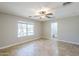Bright bedroom with tile floors, a ceiling fan, a large window, and neutral paint at 34 N Agua Fria Ln, Casa Grande, AZ 85194