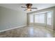 Bedroom with neutral walls, tiled floors, ceiling fan and several windows for natural light at 34 N Agua Fria Ln, Casa Grande, AZ 85194