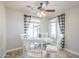 Cozy dining area with a round glass table, white chairs, and a decorative ceiling fan at 34 N Agua Fria Ln, Casa Grande, AZ 85194