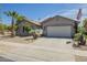 Charming single-story home featuring a two-car garage, desert landscaping, and an American flag at 34 N Agua Fria Ln, Casa Grande, AZ 85194