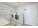 Convenient laundry room includes modern appliances, tile flooring, and access to the exterior at 34 N Agua Fria Ln, Casa Grande, AZ 85194